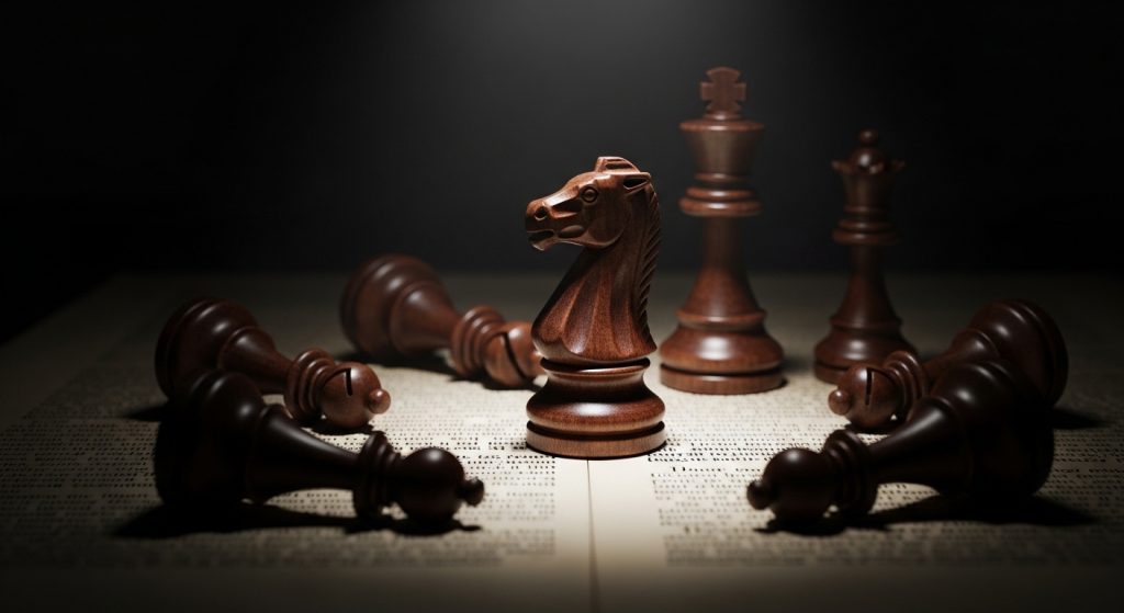 Fotografia artística de peças de xadrez marrons sobre um livro aberto. Um Cavalo permanece em pé no centro, em foco, enquanto outras peças como o Rei e a Rainha estão caídas ao seu redor, simbolizando a exceção à regra.
