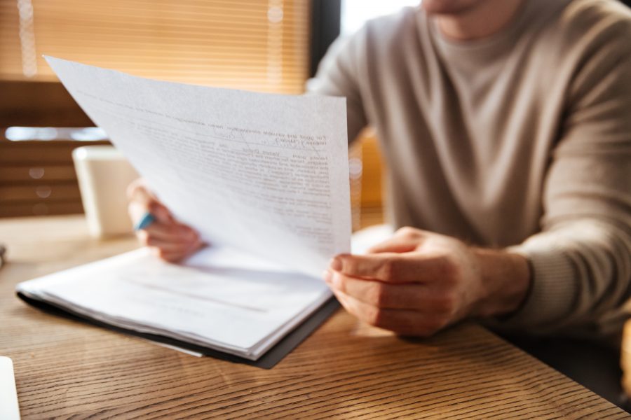 Foto recortada de um jovem em um escritório, trabalhando com documentos.