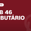 mesa de biblioteca jurídica com livros fechados, marcadores coloridos e relógio sem números (Gabarito OAB 46 extraoficial (2ª fase): Direito Tributário)
